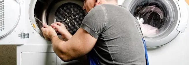 Dryer repair technician fixing a clothes dryer drum in Rockford, IL