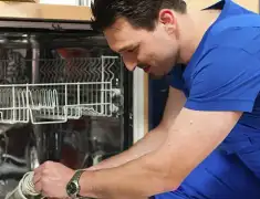 Dishwasher repair technician inspecting and servicing an open dishwasher in Rockford, IL