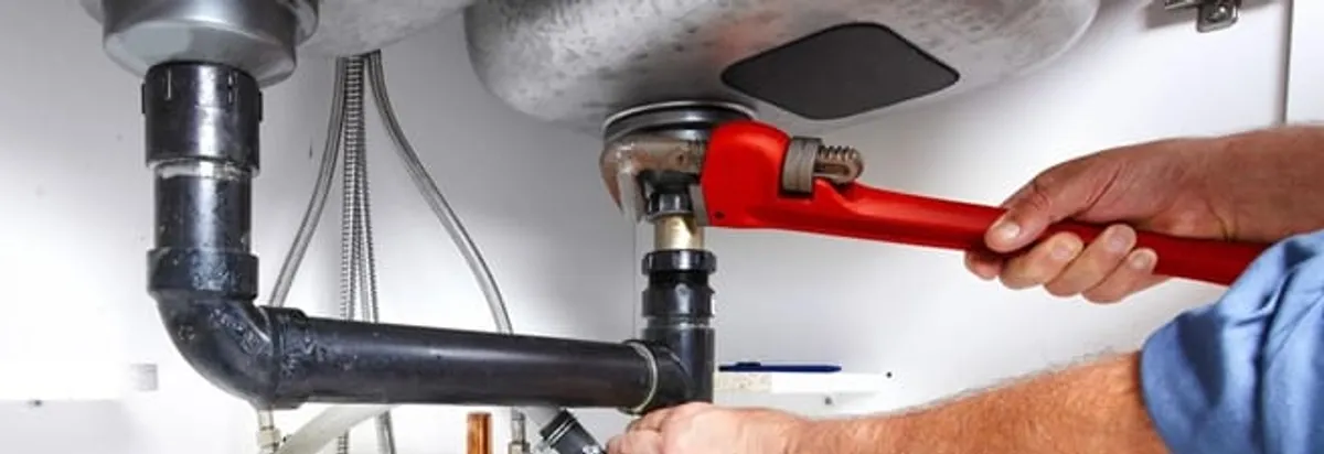 Garbage disposal repair technician tightening the sink drain and disposal connection in Rockford, IL