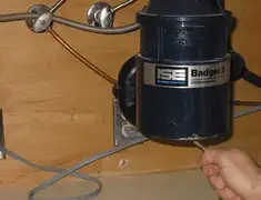 Garbage disposal repair technician tightening the mounting ring under a sink in Rockford, IL