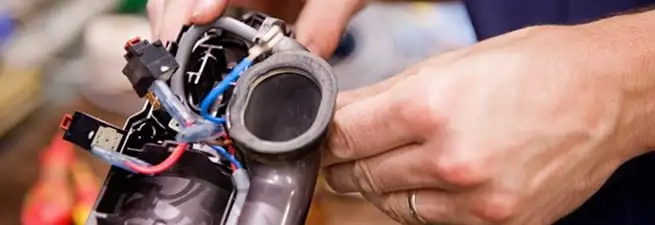 Vacuum repair technician reconnecting wiring and components in Rockford, IL