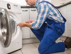 Washing machine repair technician servicing a front-load washer in Rockford, IL