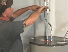 Water heater repair technician tightening supply line connections in Rockford, IL